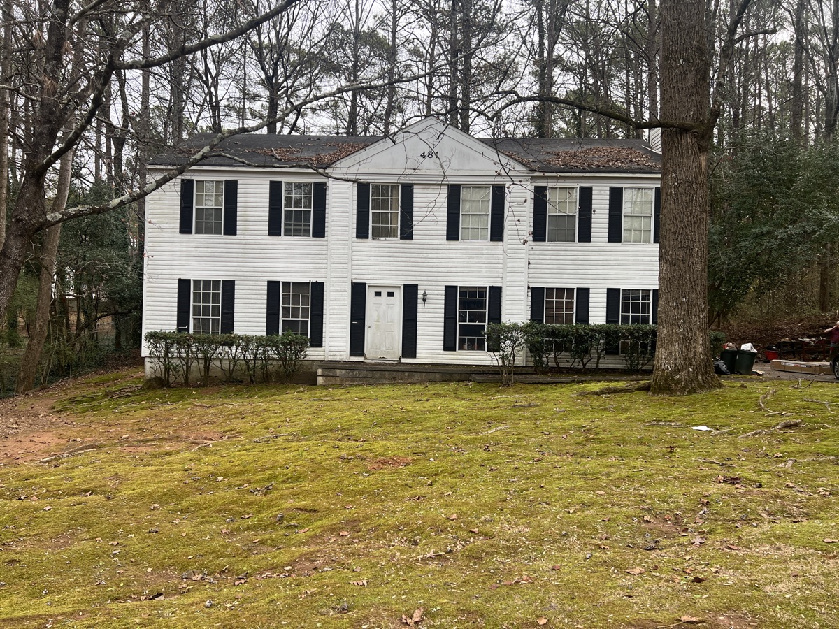 Two-story house on Halwick Way in Stone Mountain, GA before renovation, worn siding and bare yard