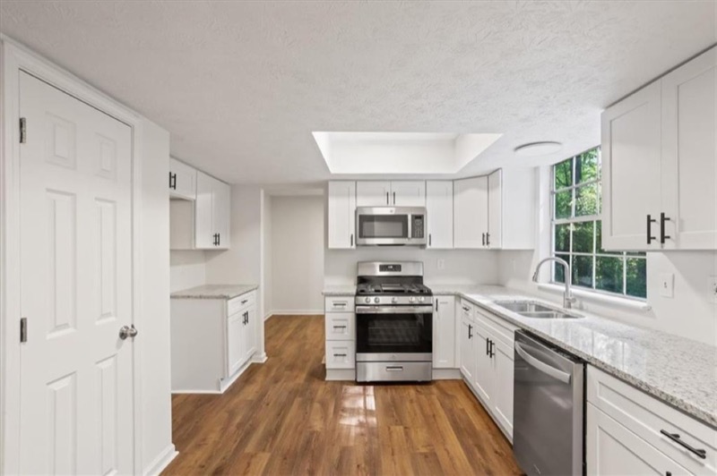 Same Stone Mountain kitchen fully renovated by Mighty Estates with white cabinets and new appliances