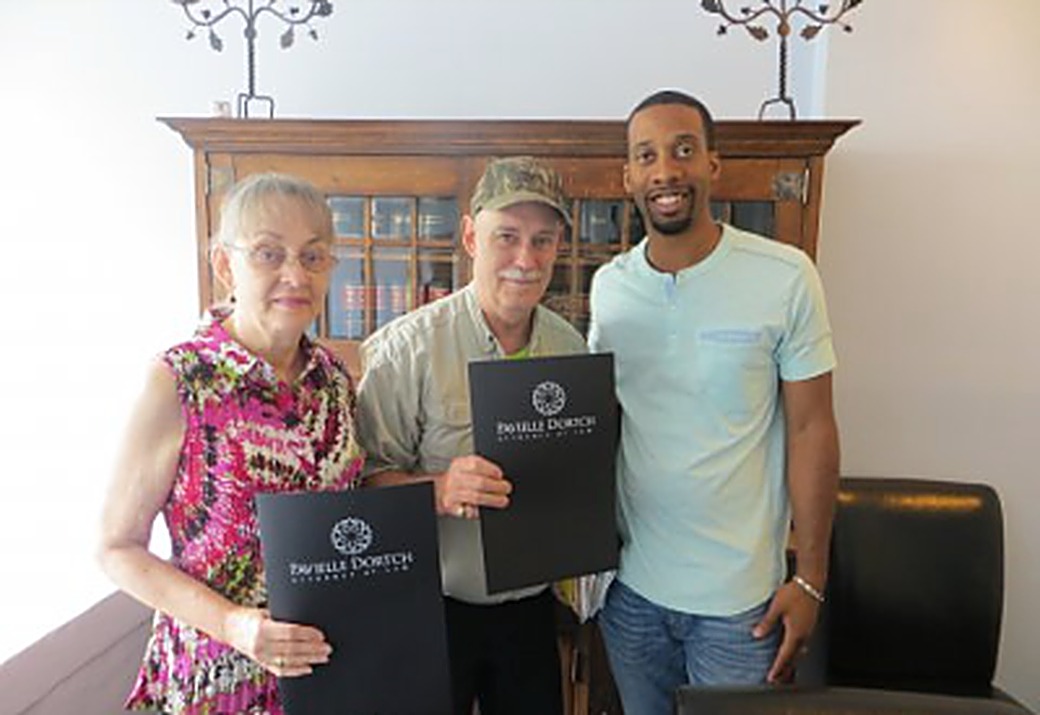 Ron and Gale Hawk with Brandon Barnes at their closing after selling their Atlanta house for cash